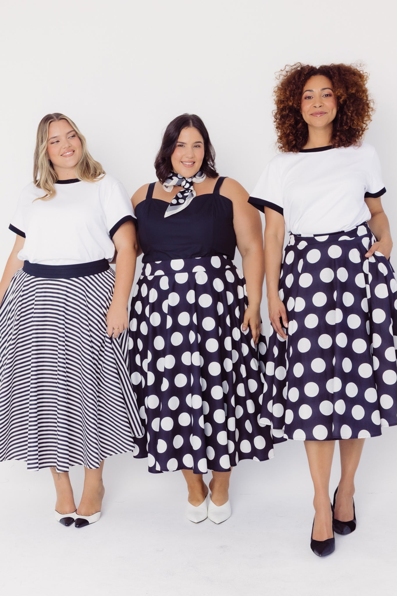 Three women wearing Cherry Bobbins polka dot and stripe cotton skirts and tops against a white background