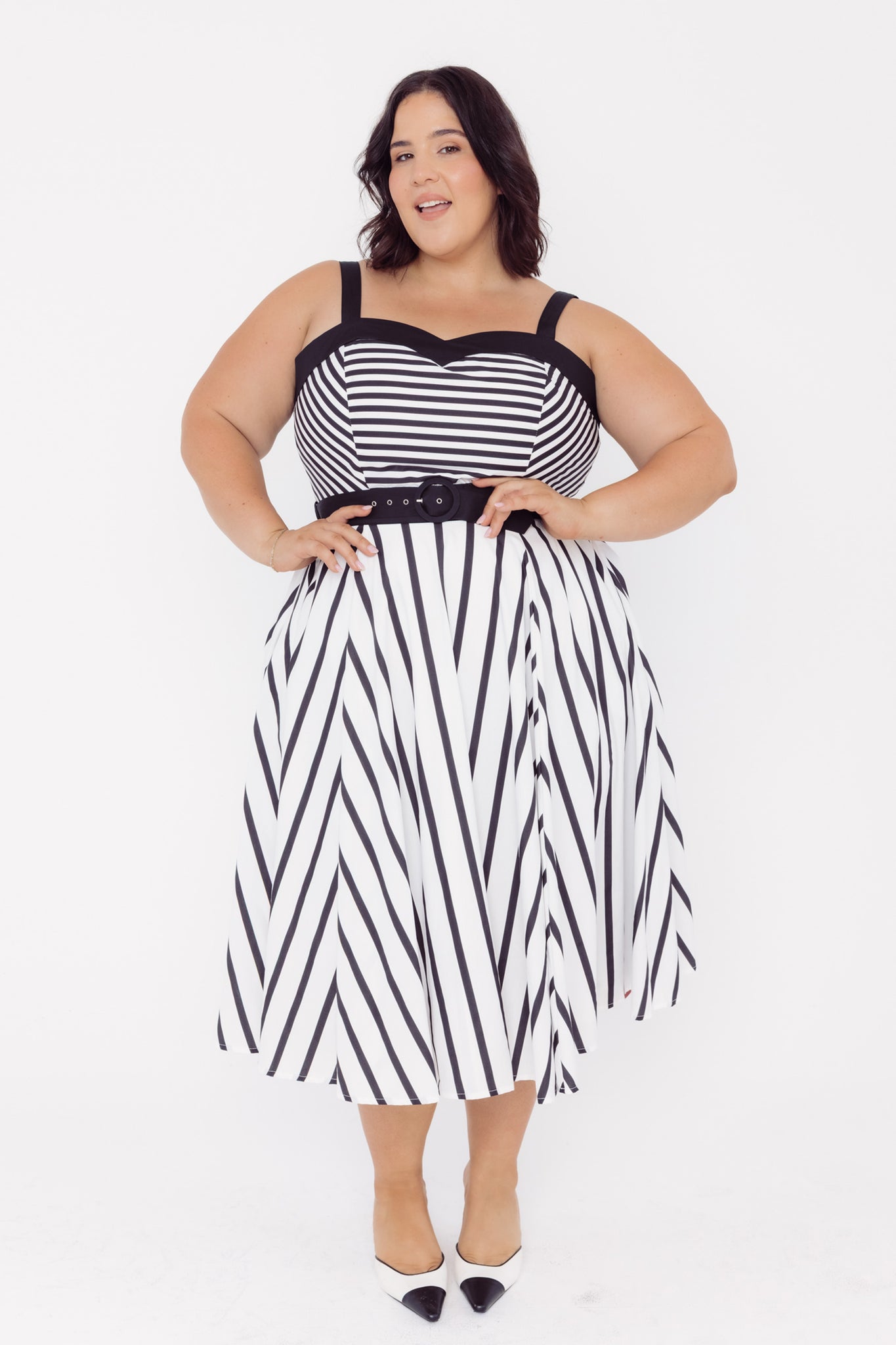 Front view of a woman wearing a Cherry Bobbins black and white striped cotton midi dress with a belt on a white background