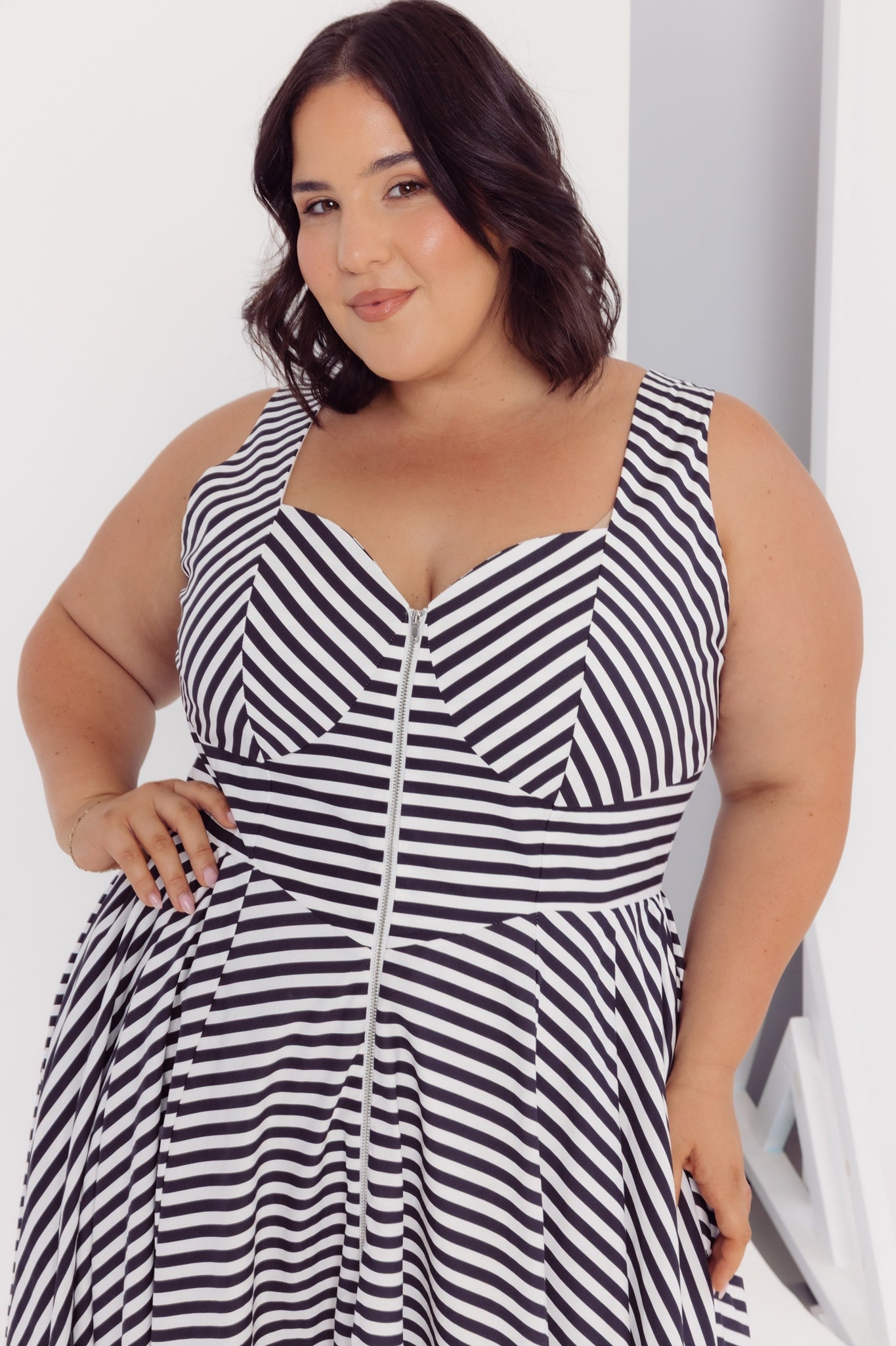Details of a woman wearing a Cherry Bobbins black and white striped cotton midi dress against a white background