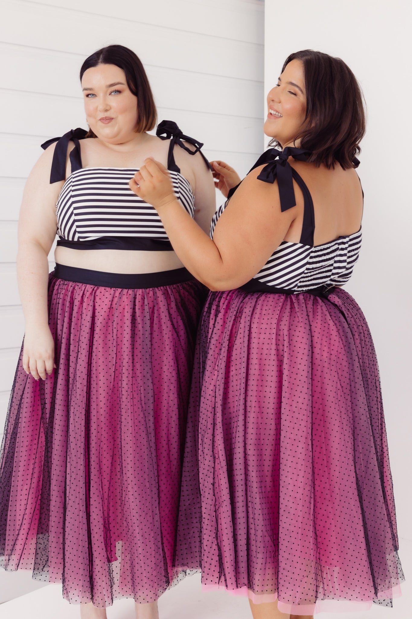 Two women wearing matching Cherry Bobbins tulle & stripe cotton outfits with a white background
