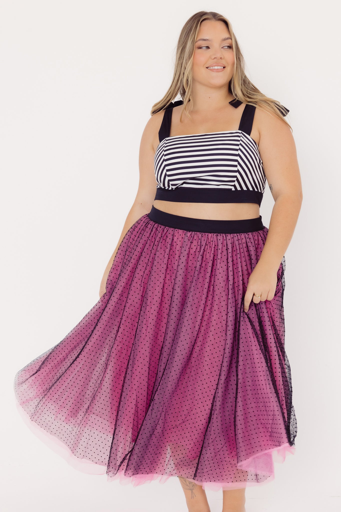 Front view of a mid-size woman wearing a Cherry Bobbins striped cotton top and pink black tulle skirt on a white background
